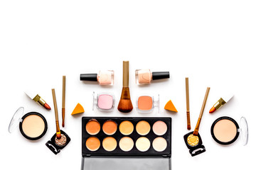 Decorative cosmetics pattern. Eyeshadows, rouge, nailpolish, brushes. lipstick on white background top view copyspace