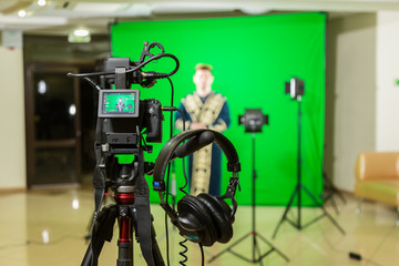The actor starred in the interior on a green background. The chroma key. Filming equipment.