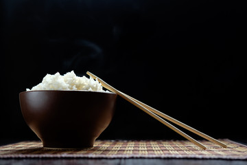 hot rice in brown bowl with chopsticks in japanese style