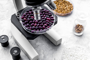 Laboratory for food analysis. Red beans under the microscope on grey background