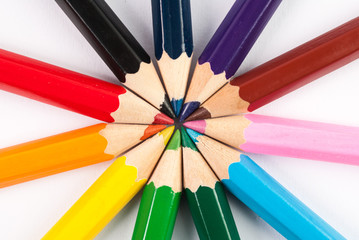 Circle of colored pencils  in the colors of rainbow on white background