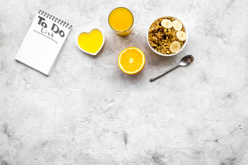 Start the day the right way. Healthy breakfast oatmeal with fruits and planning the day. Grey background top view copyspace