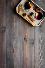 Winter tea with citrus and spices on dark wooden background top view copyspace