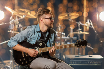 musician playing guitar at studio or music concert