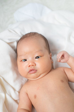 Asian new born baby boy smiling.