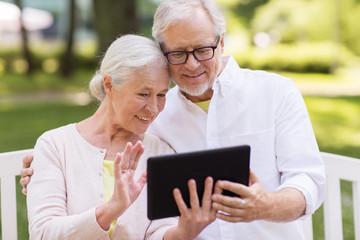 senior couple with video chat on tablet pc at park