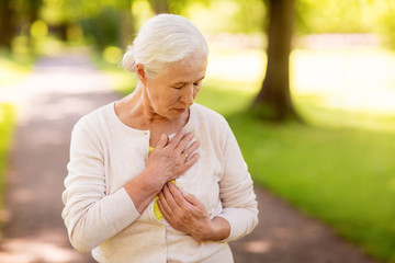 senior woman feeling sick at summer park