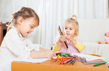  little girls sitting    and drawing.