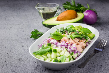 Asian avocado tuna cucumber salad on concrete background. Selective focus, copy space. 