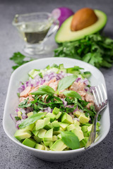 Paleo avocado tuna cucumber salad on concrete background. Selective focus, copy space. 