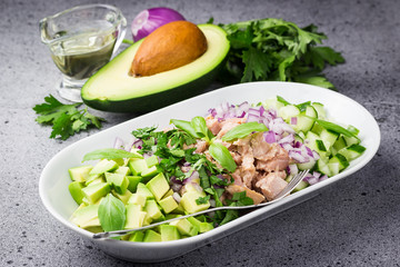 Cashew avocado tuna cucumber salad on concrete background. Selective focus, copy space. 
