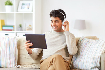 man in phones with tablet pc listening to music