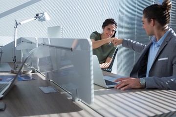 Happy executives celebrating success with fist bump