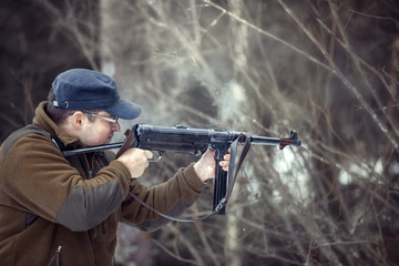 young man shoots from a German submachine gun