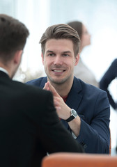 Two men discuss the growth of the company, looking at the rising graph on a computer screen