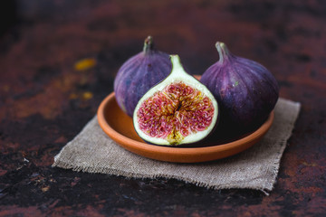 Fig fruits on clay plate on dark background.