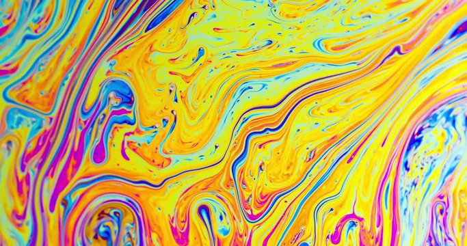 Macro shot of a soap bubble creates a colorful and psychedelic background.