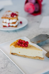 Cheesecake with red currant berries on white plate.