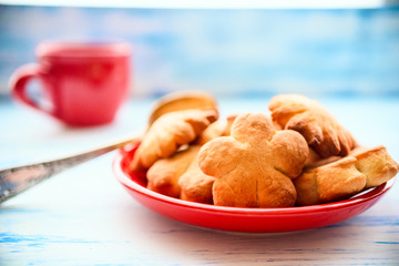 shortbread cookie in a red plate and coffee in a red mug for breakfast