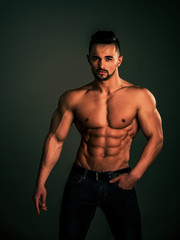 Athletic bodybuilder man on black background.