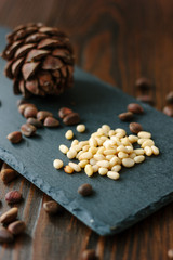 Clean pine nuts on black kitchen board.