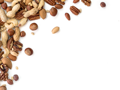Background of nuts - pecan, macadamia, brazil nut, walnut, almonds, hazelnuts, pistachios, cashews, peanuts, pine nuts - with copy space. Isolated one edge. Top view or flat lay