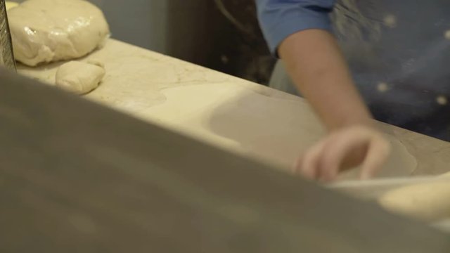 Male hands rolling dough with rolling pin for baking 4K