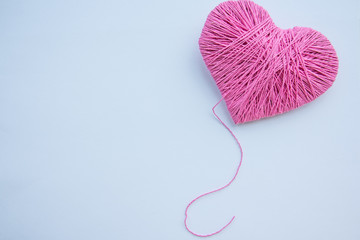 Colorful yarn ball isolated on white background. Space for text. Pink heart like a symbol of love. Hobby concept