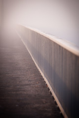 Bridge fence with vehicle lights in background going to perspective