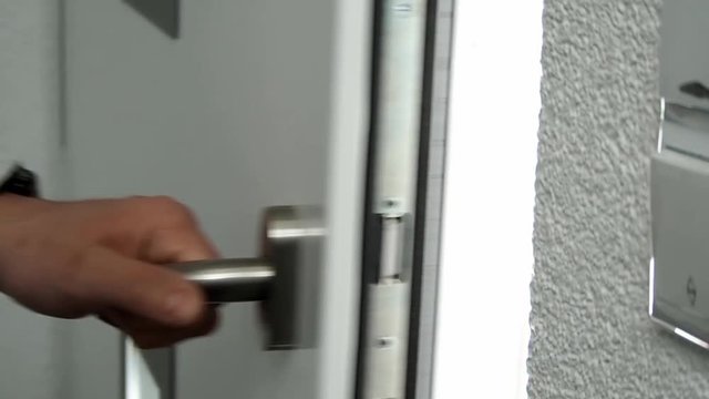 Mann öffnet weiße haus Tür mit Hand und geht raus