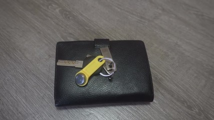 the hand of the young man puts on the table a wallet and keys,concept of the person comes home.