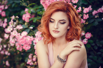 Fototapeta premium Lovely young woman in a pink dress, waiting for a date.