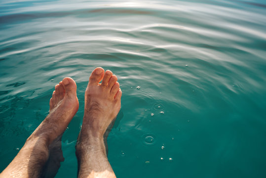 Male feet in outdoor swimming pool
