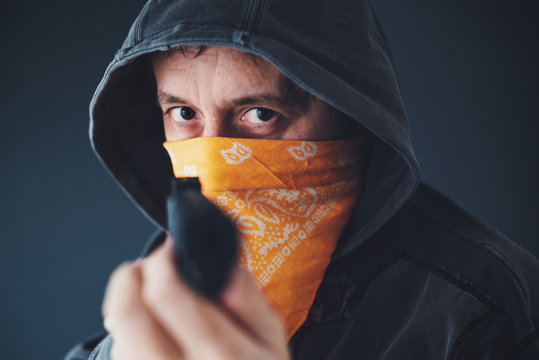Hooded gang member criminal with gun