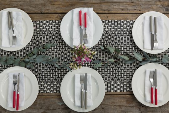 Plates with napkin, fork, butter knife and flower arranged on