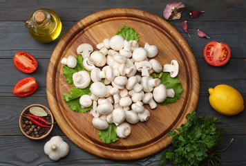 mushrooms with tomatoes, parsley, oil, garlic, chili pepper, peppercorns on dark wooden background. top view