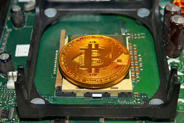 Golden Bitcoin Cryptocurrency on computer circuit board. Macro shot