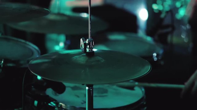 The drummer plays in a nightclub. Drum sticks hit the plates. Video with shallow depth of field