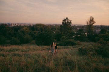 Young couple in love outdoor. Beautiful nature and warm sunset 