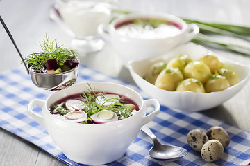 Cold vegetable soup with eggs  in white bowl on wooden table.