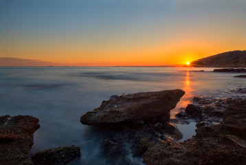 The calm sea in a very cloudy sunset