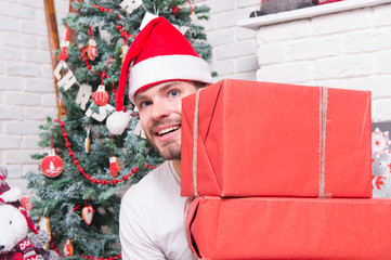Macho in red hat smile with wrapped presents