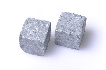 Two grey stones for whiskey were lying on a white background. The whisky stones close up.