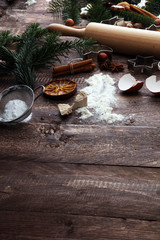 Baking ingredients for homemade pastry on wooden background with cookies and spieces