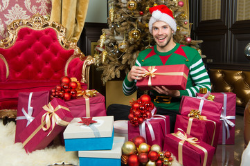 Obraz na płótnie Canvas Macho in elf costume prepare gift boxes