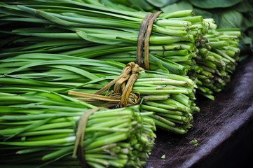 Bundles of the Chinese Vegetable Jiu Cai or commonly known as Garlic Chives for sale in a market in Zhaodong China. - obrazy, fototapety, plakaty