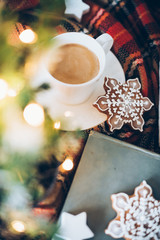 Christmas decoration with a cup of coffee, gingerbread and plaid