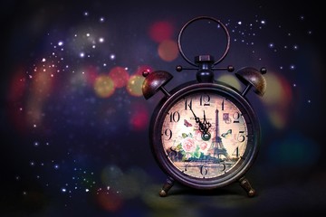 Close up of an old vintage watch with colorful bokeh and Eiffel tower print and sparkles