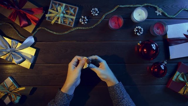 Man opens candy, eats it and throws wrapper on New Year decorated desk, top down shot