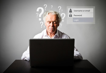 Old man using a laptop. Forgot password concept.
